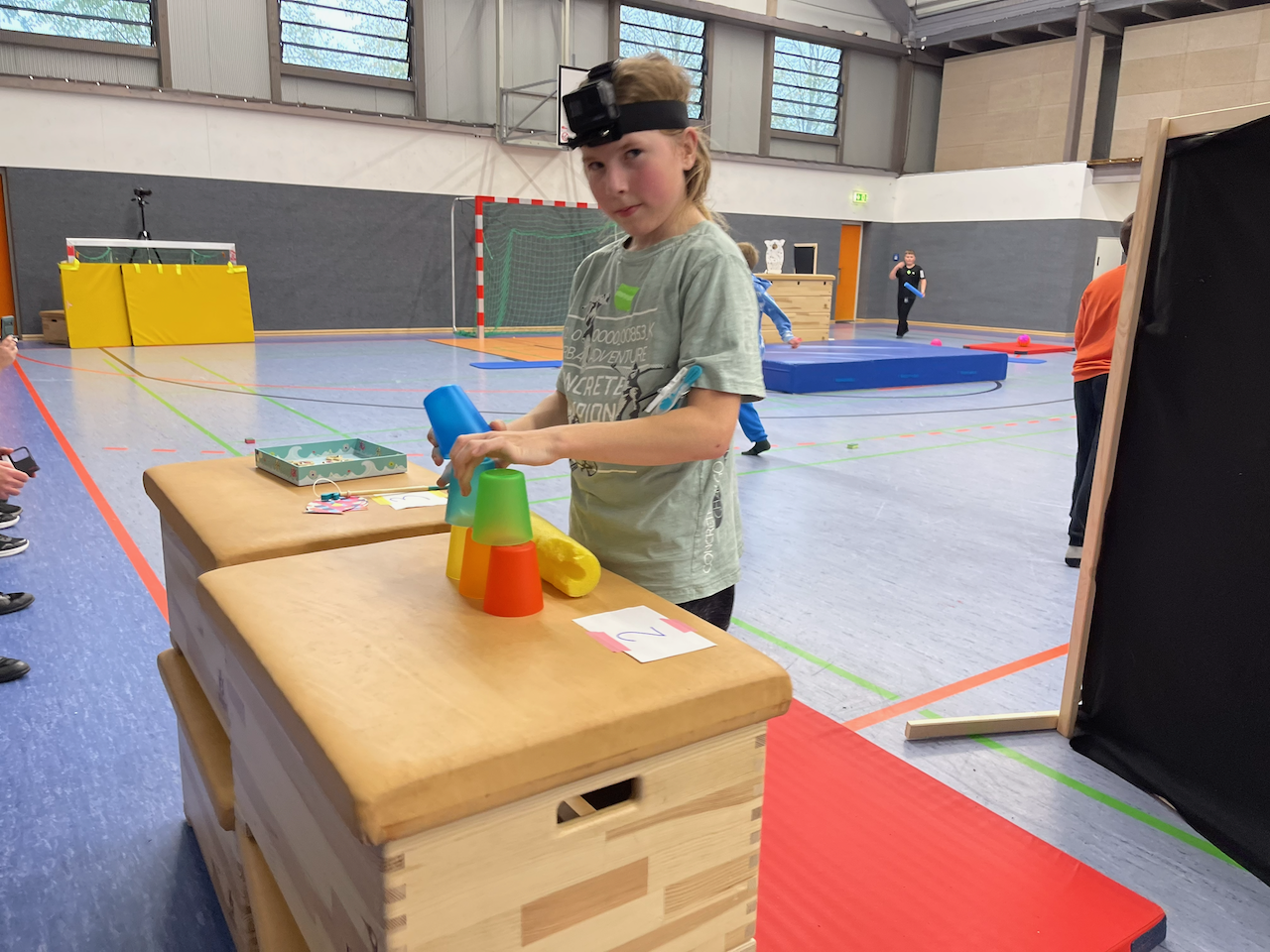 Junge spiel Becher-Stapeln in einer Turnhalle