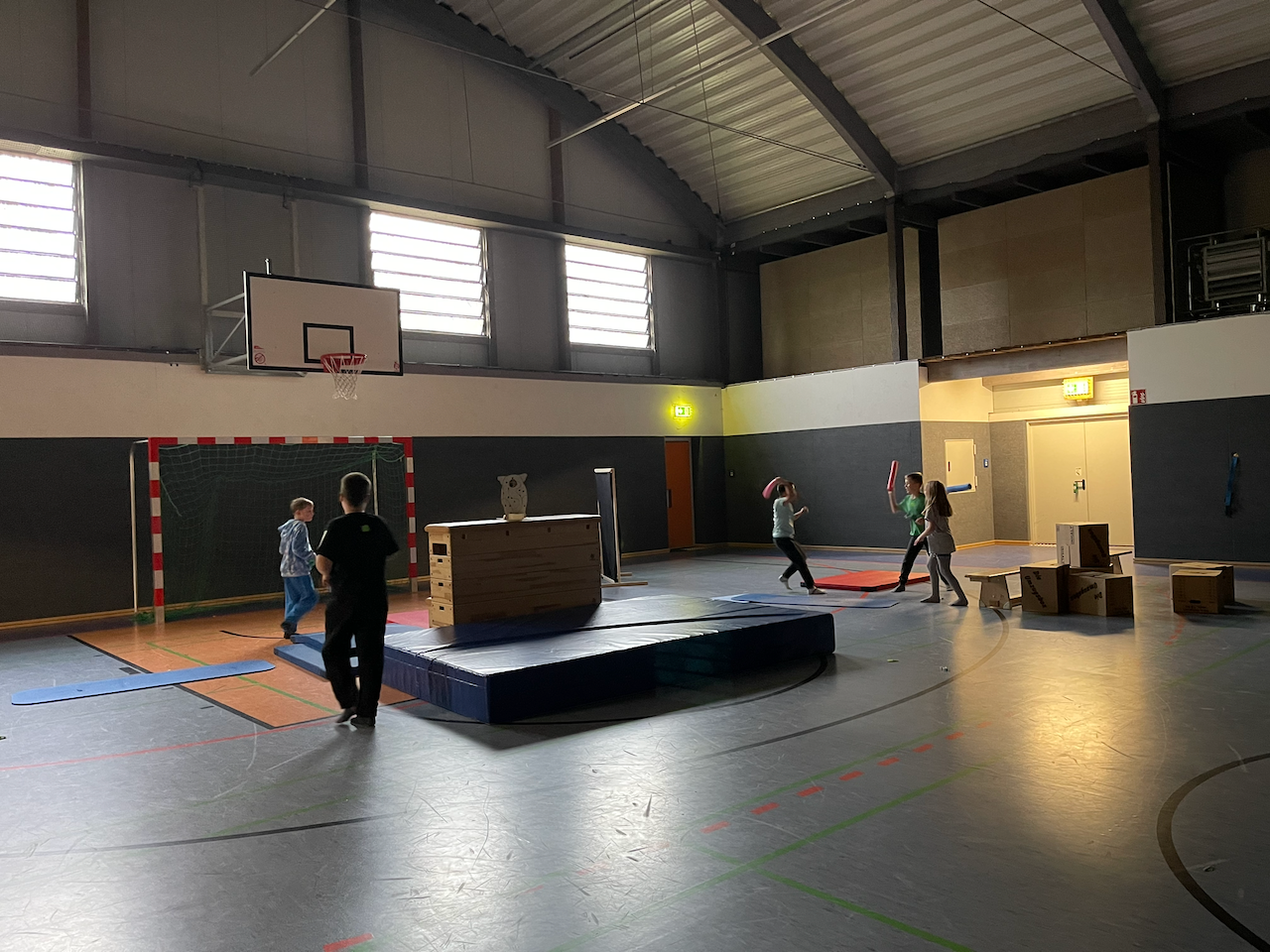 Kinder spielen Jumanji in einer dunklen Turnhalle
