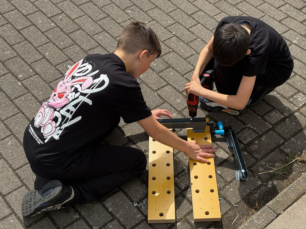 Zwei Jungen bauen eine Werkbank auf