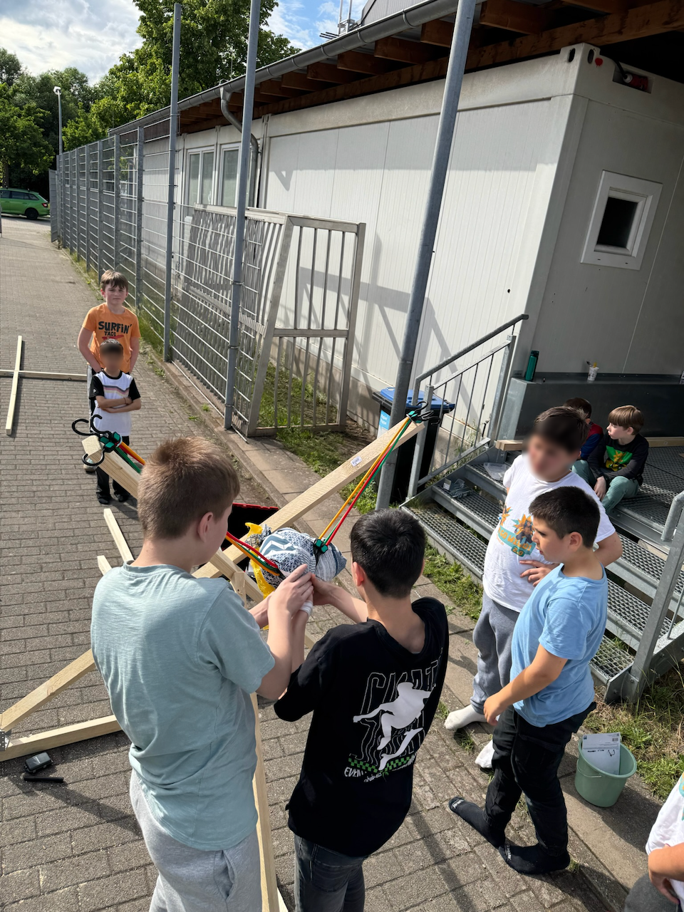 Jungs testen ein selbstgebautes Katapult.