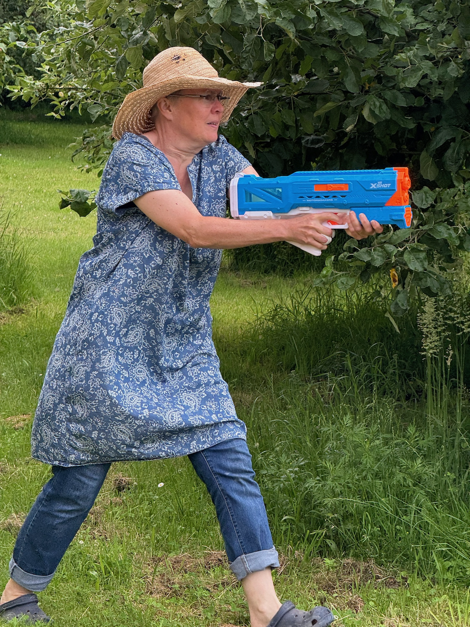 Frau läuft mit Wasserpistole im Anschlag