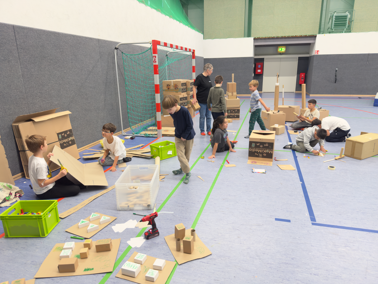 Kinder basteln in einer Turnhalle