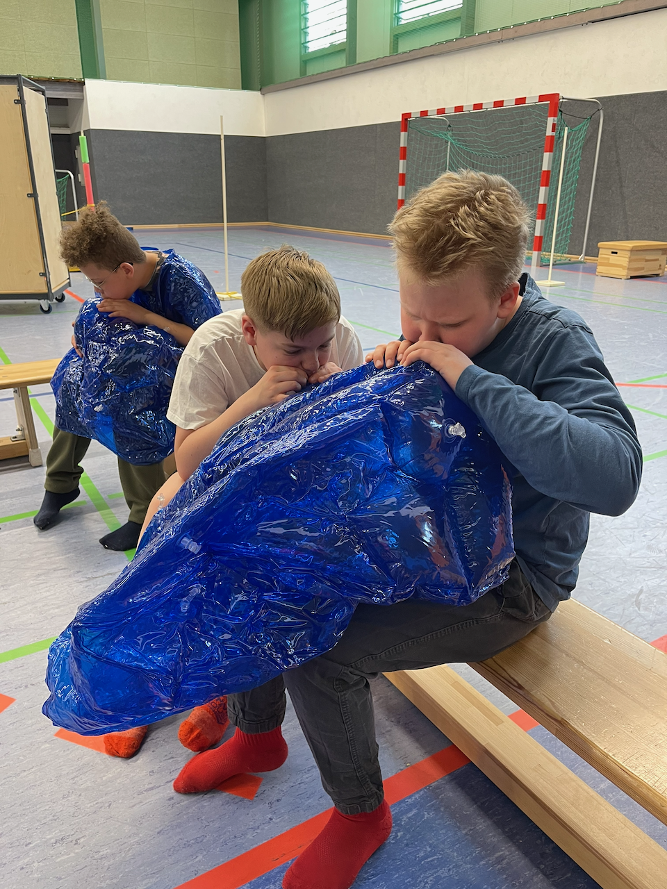 Jungen pusten Sumo-anzüge auf.