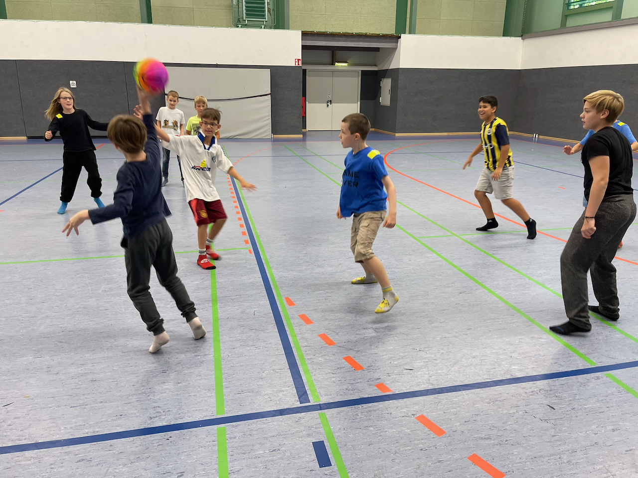 Jungen spielen Brennbal in einer Turnhalle