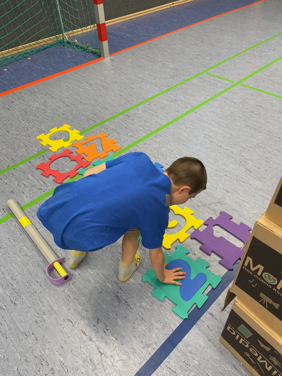Junge legt Zahl in großes Schaumstoffpuzzle