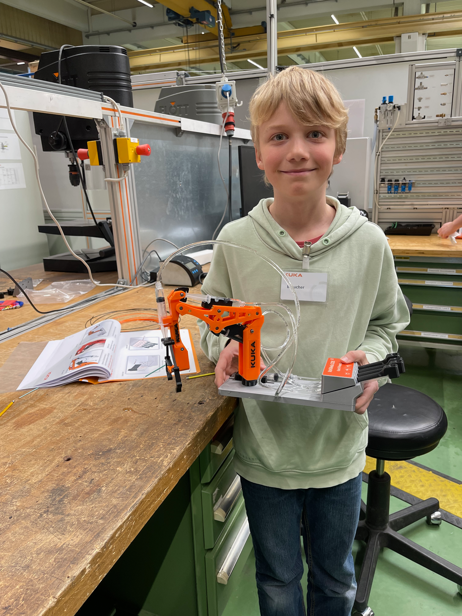 Bei Kuka: Junge mit zusammengebautem roboterarm