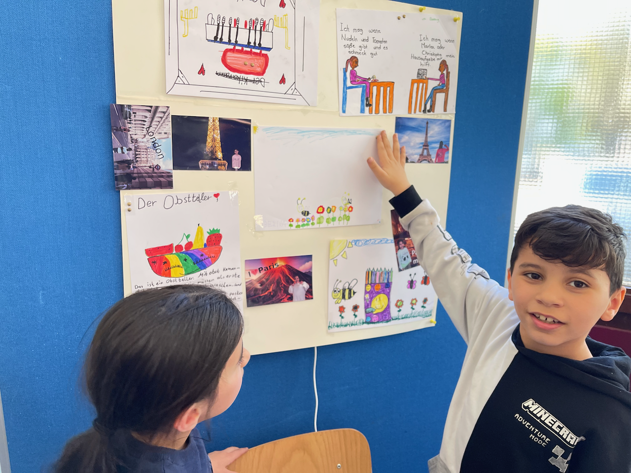 Zwei Kinder an einem interaktiven Plakat.
