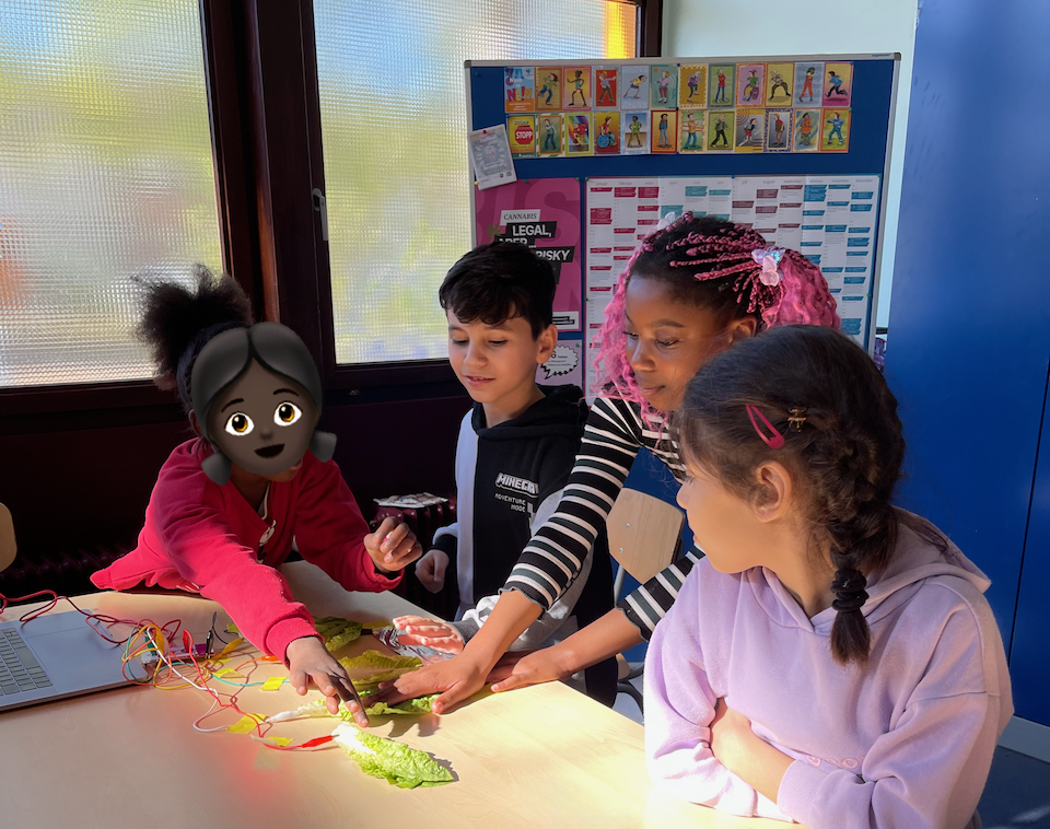 drei Kinder probieren das Salat-Klavier mit dem Makey Makey aus.